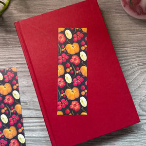 Red book with tomato pattern on a wooden surface