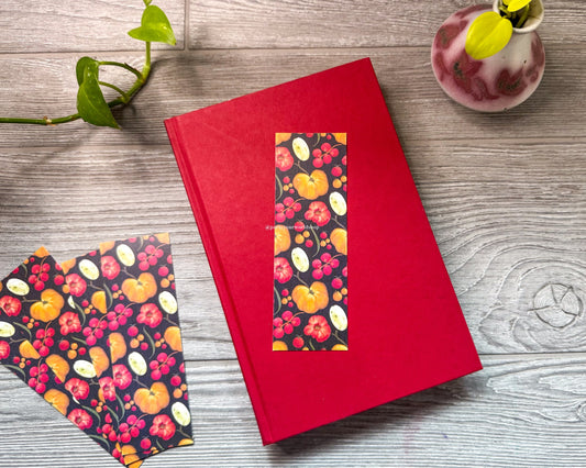 Red book with tomato pattern on a wooden surface