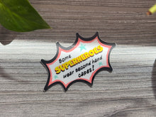 Load image into Gallery viewer, Comic-style badge with text &#39;Some superheroes wear second hand capes!&#39; on a wooden surface.