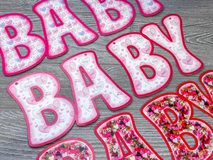 Welcome baby girl banner with pink and white decorations, perfect for celebrating the arrival of a precious little girl.