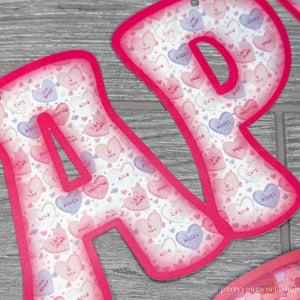 Happy Valentine's Day paper banner with watercolor pink and purple conversation heart pattern letters by Party Your World