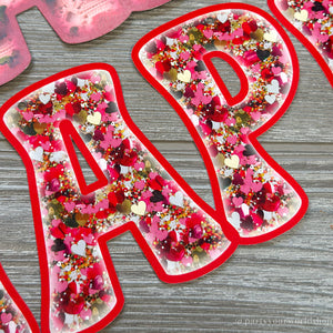 Happy Valentine's Day paper banner with red and gold faux glitter letters, spreading love and joy.