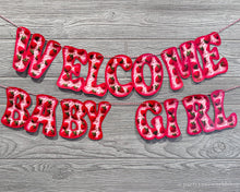 Load image into Gallery viewer, Welcome baby girl banner with pink and purple conversation heart pattern letters, adorned with hearts. A joyful celebration of a new arrival.